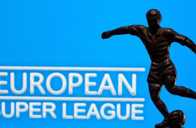 A metal figure of a football player with a ball is seen in front of the words "European Super League" in this illustration taken April 20, 2021. REUTERS/Dado Ruvic/Illustration/File Photo